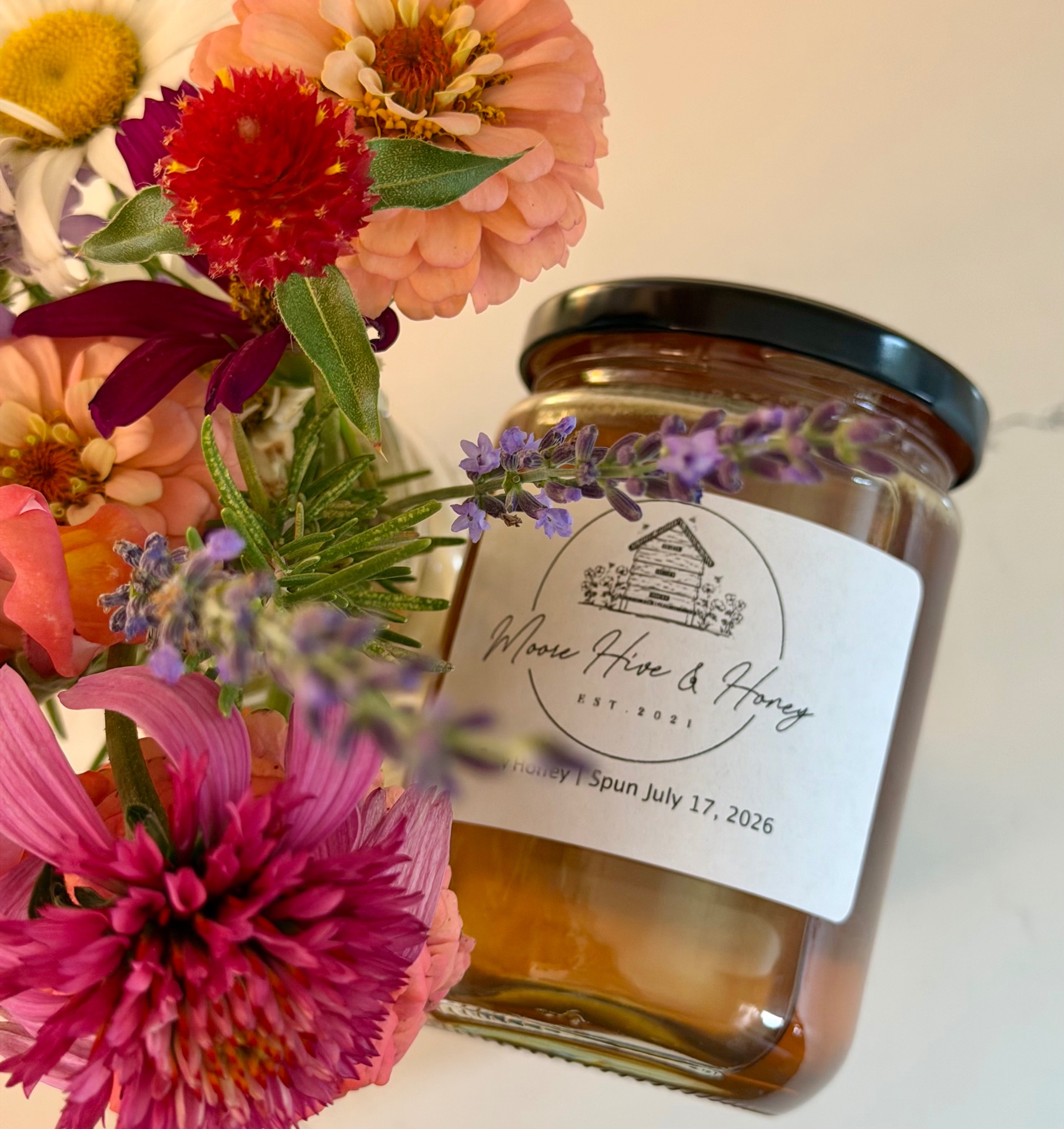 Moore Hive & Honey jar surrounded by a garden bouquet